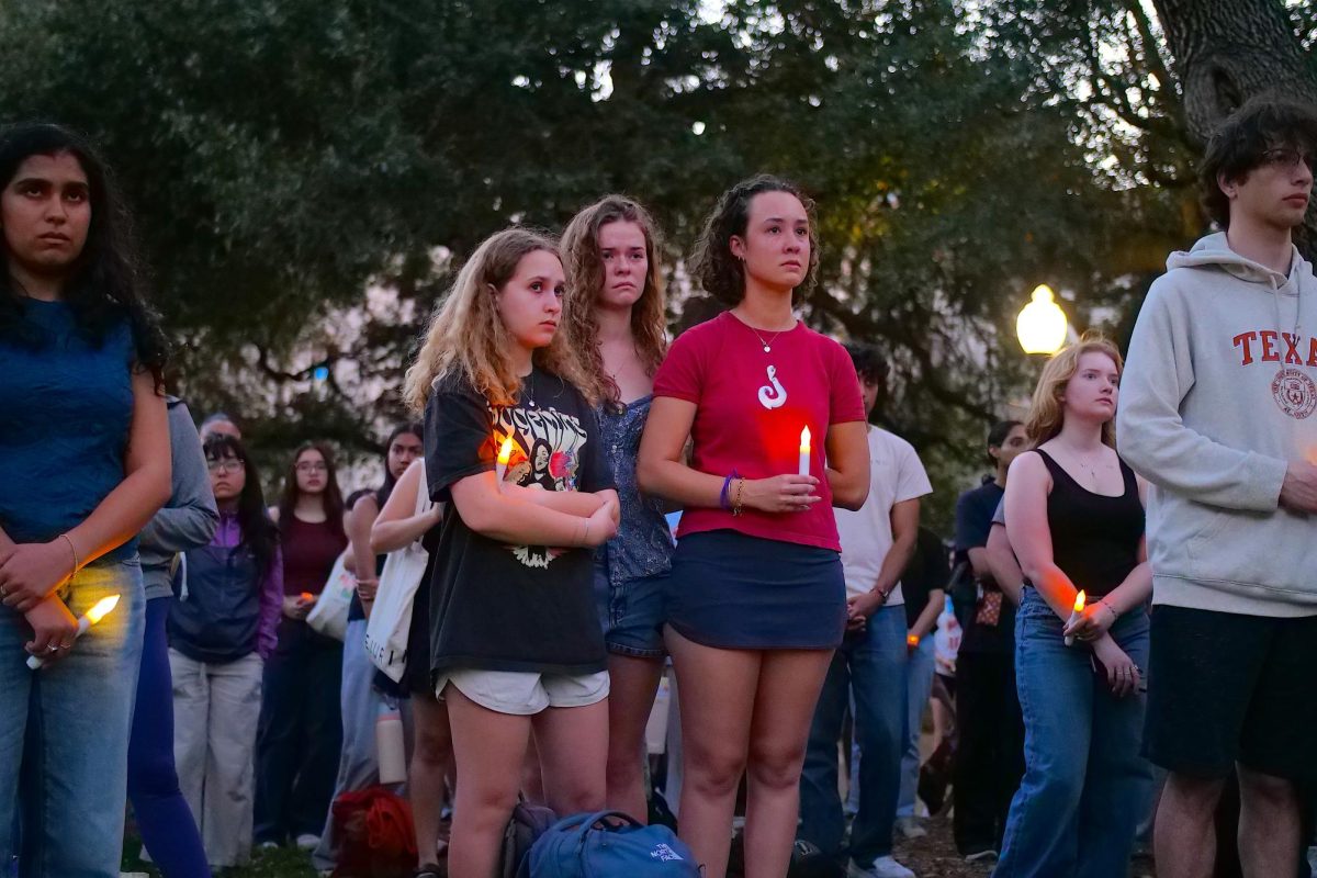 A group of students hold candles at a vigil for the victims of a mass shooting at Buford's near the Main Building at the University of Texas at Austin on March 4th, 2026.
